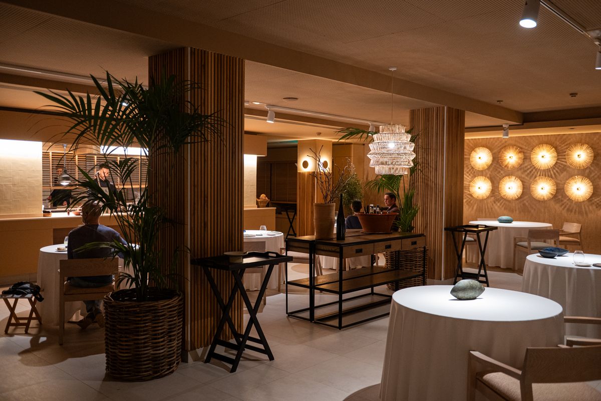 La sala de Sol Post de noche, con la cocina abierta al fondo