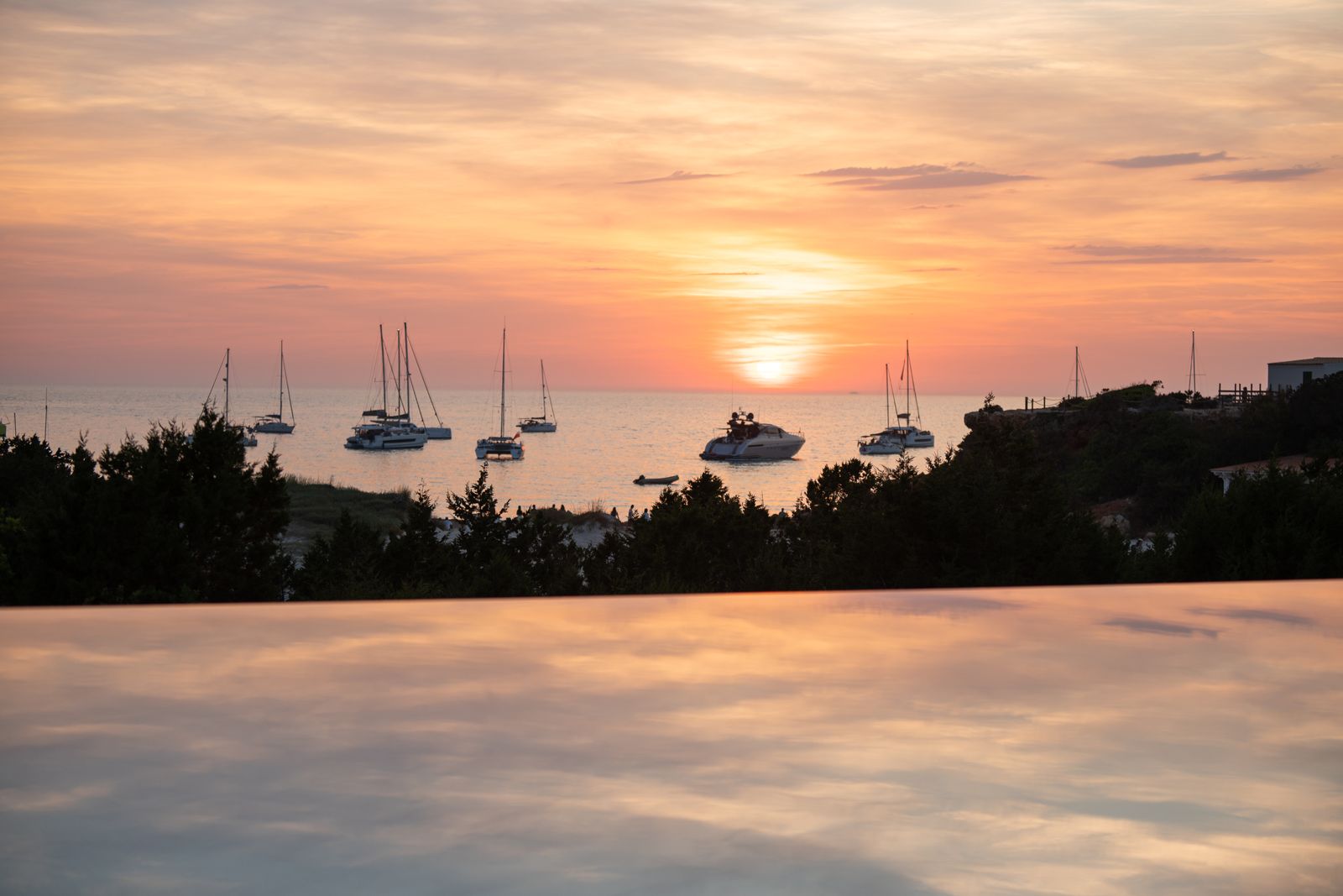 El sol se pone sobre el mar de Cala Saona, reflejado en la lámina de agua